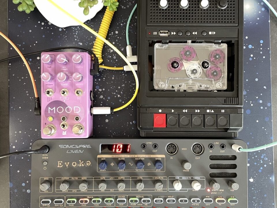 Mit dem Sonicware Liven Evoke habe ich einem Organ Sound über die Grain-FX etwas „Glitzern“ hinzugefügt, ihn auf einem Mini Mello aufgenommen und den Akkord dann mit unterschiedlichen Bandgeschwindigkeiten über die Tasten abgespielt. Der Reverb kommt aus dem Chase Bliss MOOD MK II.